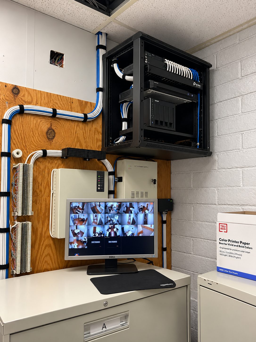 ISEEU TECHS installation: organized server room corner with rack, structured cabling and camera monitor